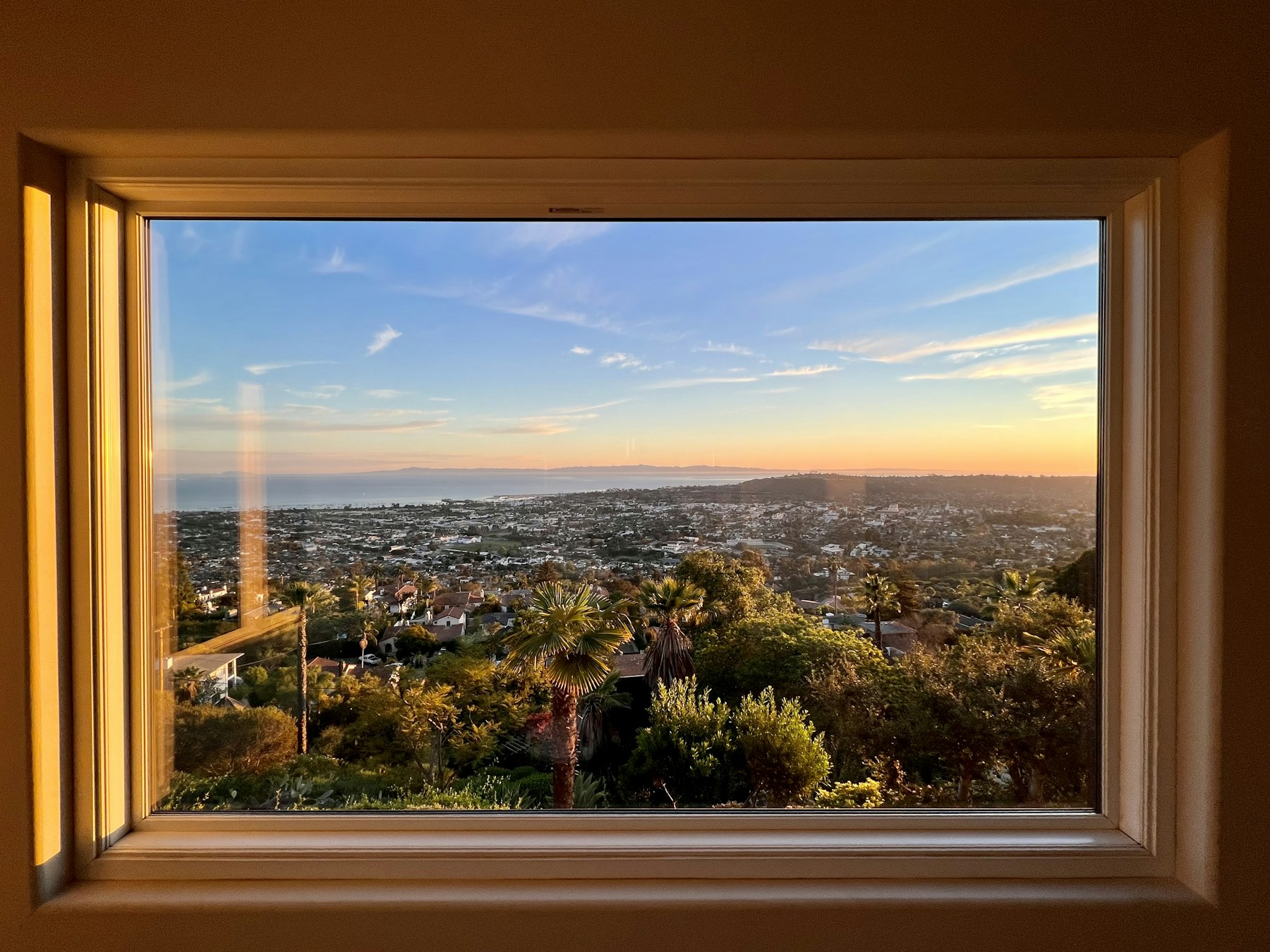 Santa Barbara and the ocean seen from a window at golden hour